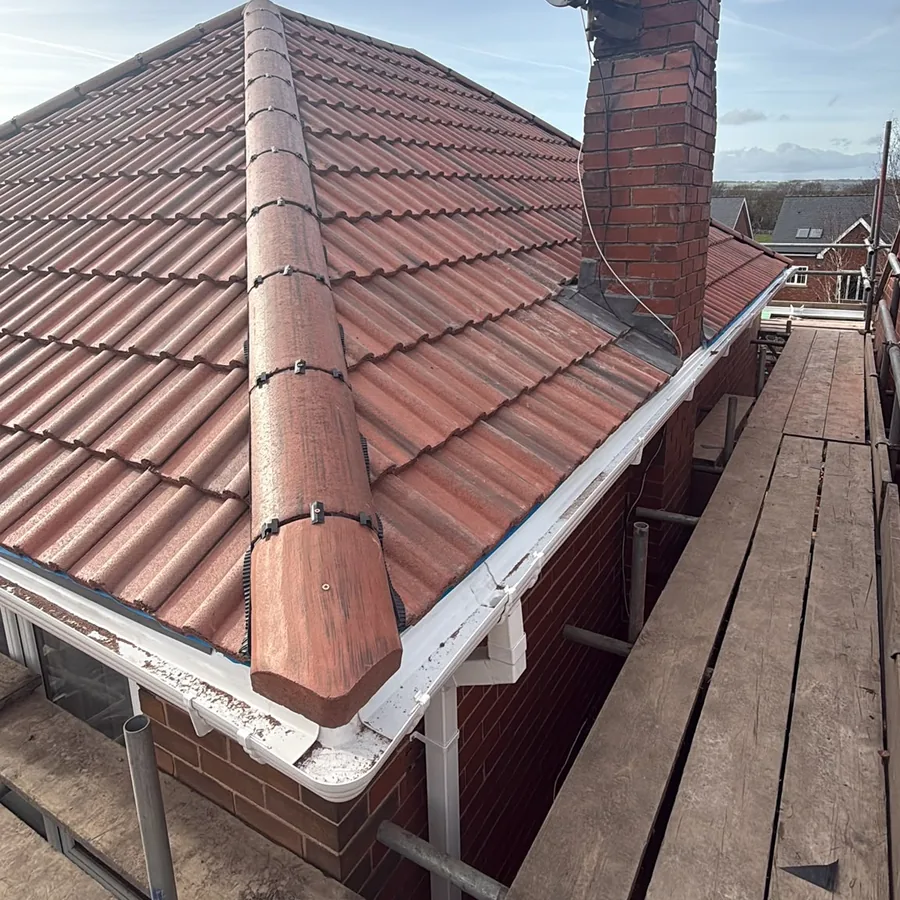 Dry-fixed hip and new red tiles beside the chimney