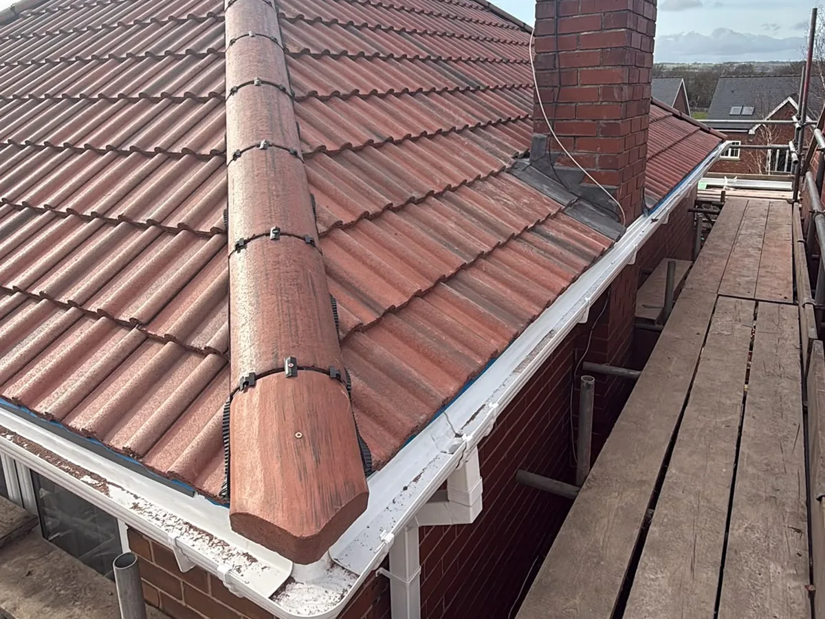 Dry-fixed hip and new red tiles beside the chimney