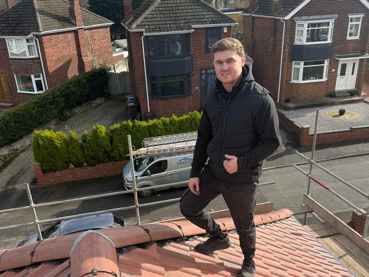John Smith on a finished red tiled roof, with the Taylored Roofing van below