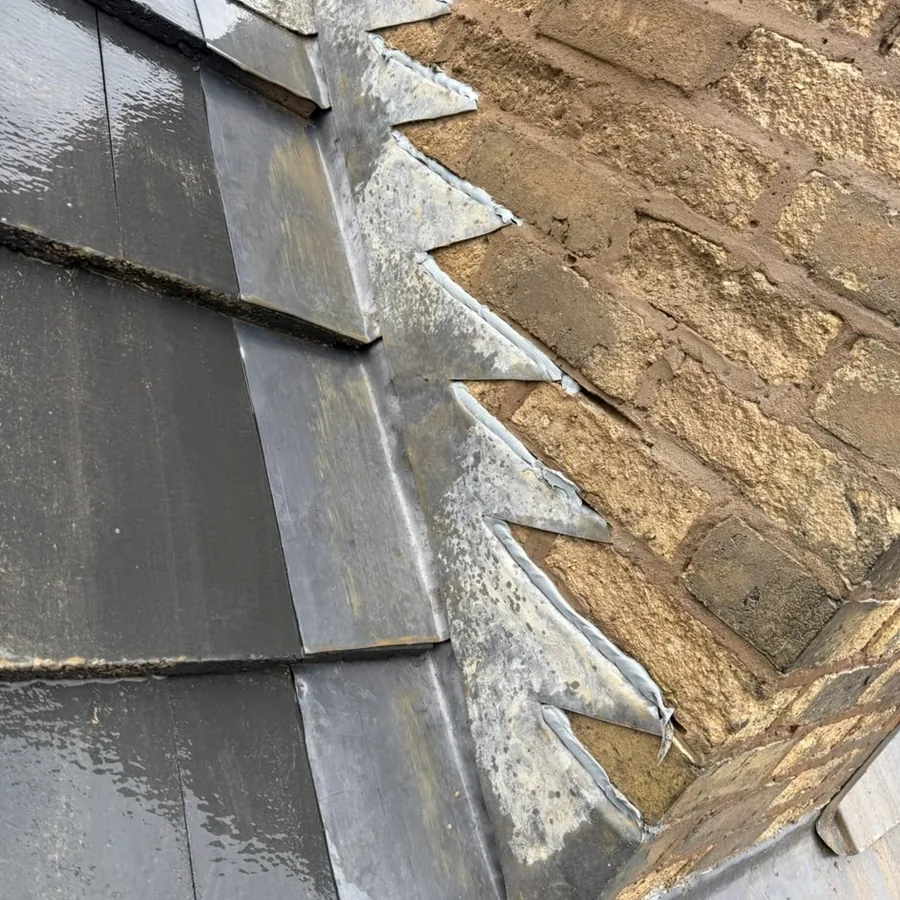 Stepped lead flashing against a stone chimney