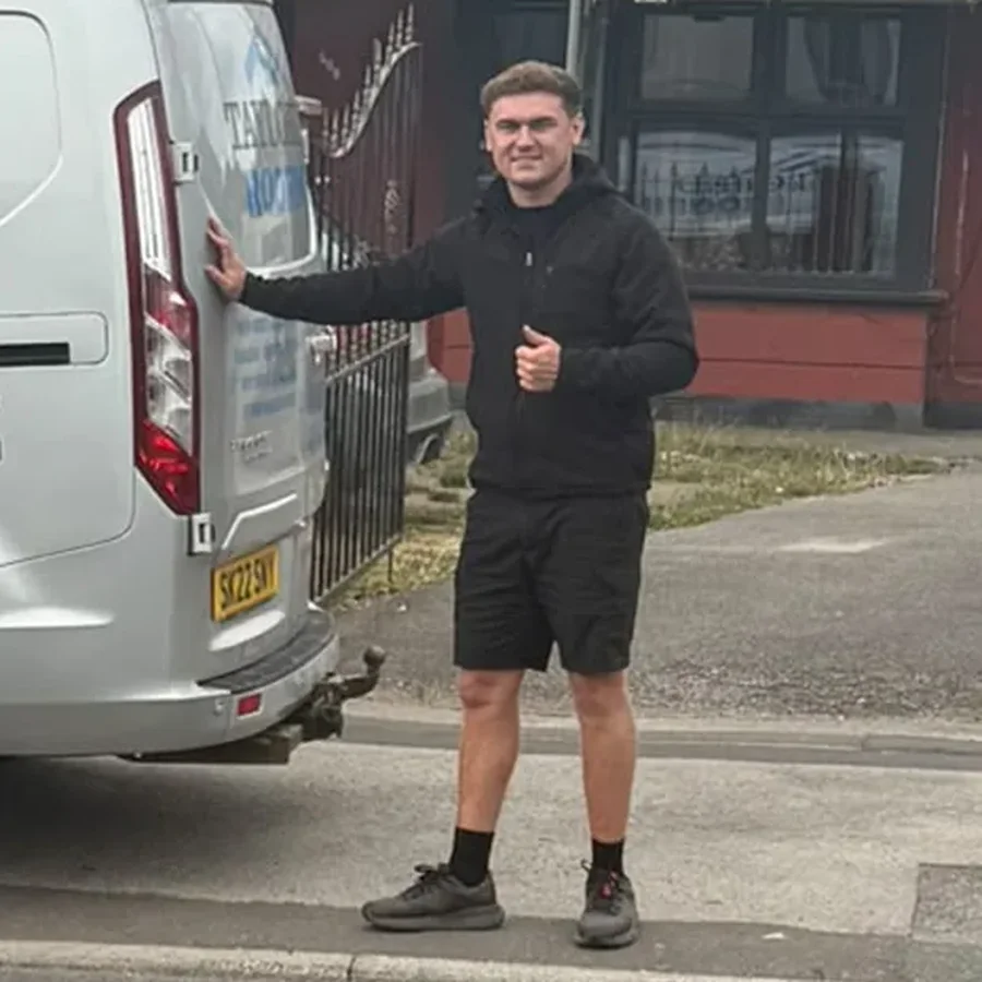 John Smith, owner of Taylored Roofing, next to the company van